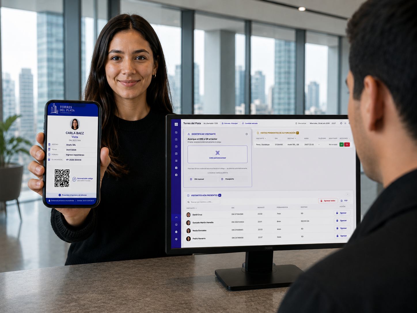 Visitante mostrando su credencial QR en el celular, con el dashboard de Visitapro en pantalla
